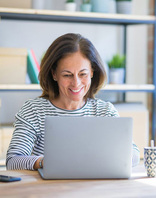 woman using a laptop and smiling